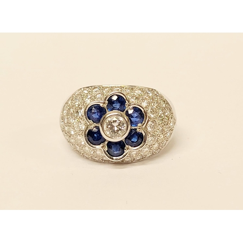 82 - A PRETTY 18CT WHITE GOLD SAPPHIRE & DIAMOND FLORAL CLUSTER / DRESS BOMBE SHAPED RING, the curved set... 