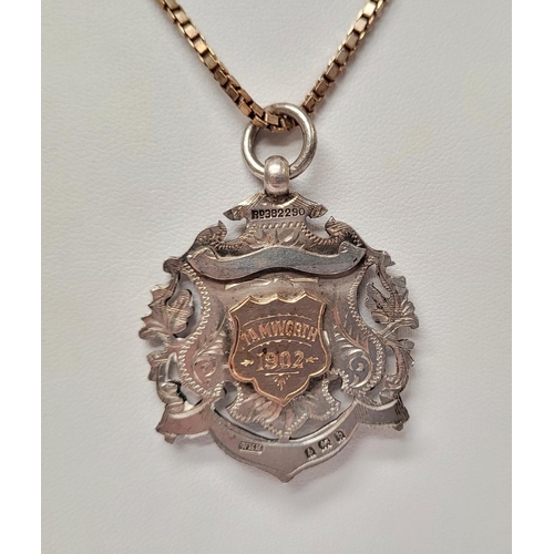 88 - AN EARLY 20TH CENTURY SILVER MEDAL ON AN ITALIAN SILVER CHAIN, the medal with an engraved open work ... 