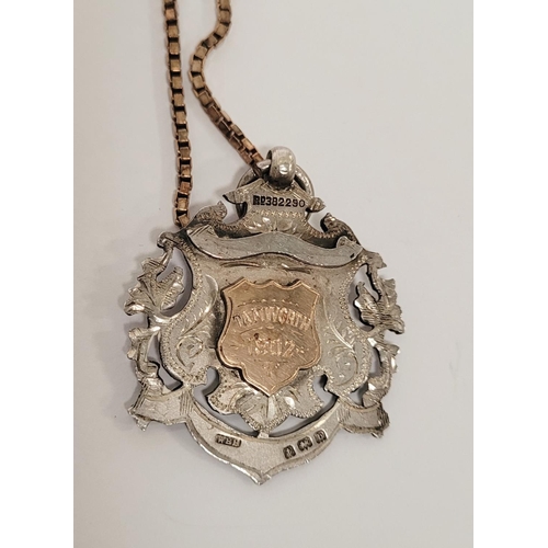 88 - AN EARLY 20TH CENTURY SILVER MEDAL ON AN ITALIAN SILVER CHAIN, the medal with an engraved open work ... 