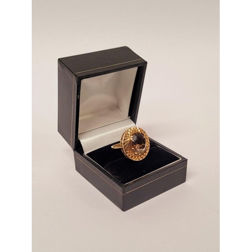 104 - A VERY FINE 9CT YELLOW GOLD SMOKY QUARTZ DRESS RING, the large oval shaped smoky quartz stone is set... 