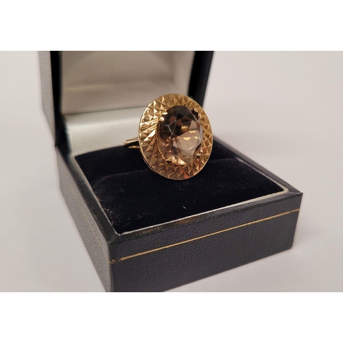 104 - A VERY FINE 9CT YELLOW GOLD SMOKY QUARTZ DRESS RING, the large oval shaped smoky quartz stone is set... 