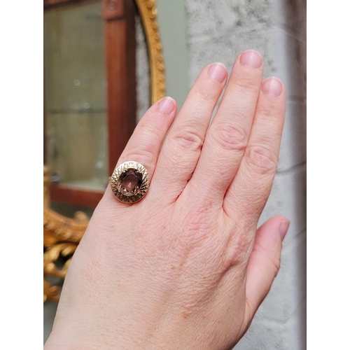 104 - A VERY FINE 9CT YELLOW GOLD SMOKY QUARTZ DRESS RING, the large oval shaped smoky quartz stone is set... 