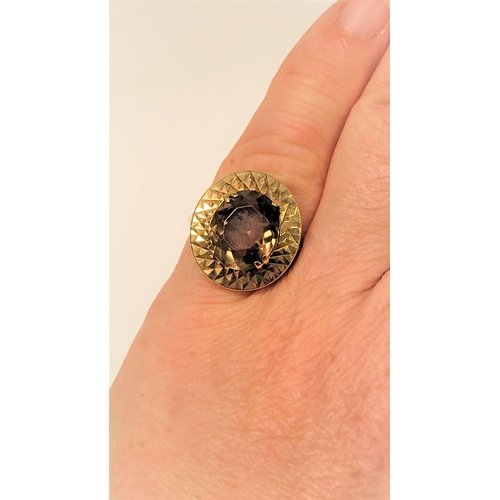 104 - A VERY FINE 9CT YELLOW GOLD SMOKY QUARTZ DRESS RING, the large oval shaped smoky quartz stone is set... 