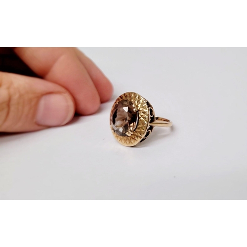 104 - A VERY FINE 9CT YELLOW GOLD SMOKY QUARTZ DRESS RING, the large oval shaped smoky quartz stone is set... 