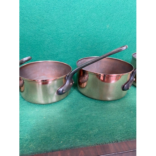 106 - A GOOD QUALITY SET OF FIVE GRADUATED COPPER SAUCEPANS, with heavy steel handles. In good, clean cond... 