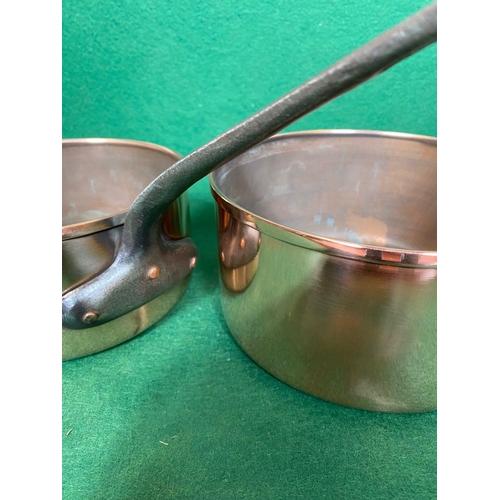 106 - A GOOD QUALITY SET OF FIVE GRADUATED COPPER SAUCEPANS, with heavy steel handles. In good, clean cond... 