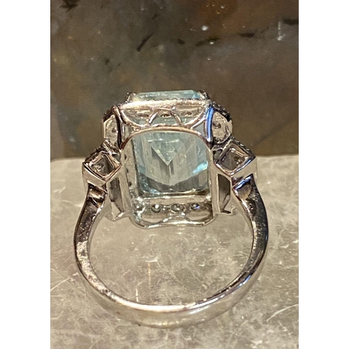 117 - A BEAUTIFUL 18CT WHITE GOLD AQUAMARINE & DIAMOND CLUSTER RING, the central claw set aquamarine weigh... 