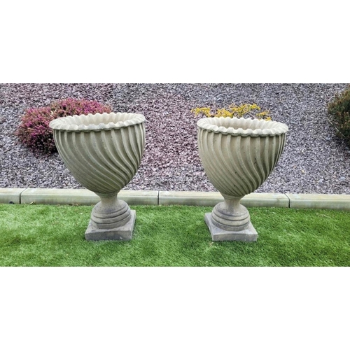 199 - A PAIR OF STONE GARDEN RAVENNA URNS, design in relief to body, standing on square platform base. Dim... 