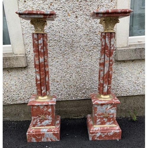 220 - A PAIR OF CORINTHIAN COLUMN MARBLE PEDESTAL STANDS, mottled red marble with stepped top above gilt s... 