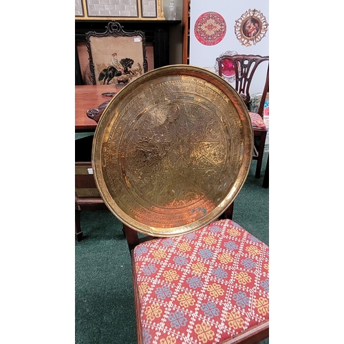 229 - TWO POLISHED BRASS DECORATIVE TRAYS, (i) One a brass zodiac charger/tray; decorated with figures in ... 