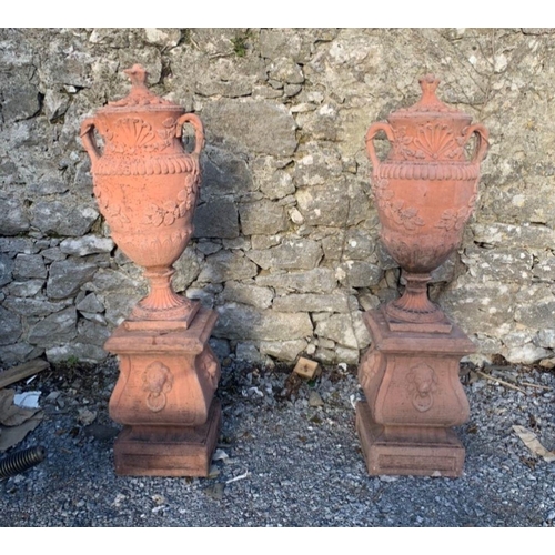 232 - A PAIR OF TERROCOTTA GARDEN URNS, covered urns with two handles, shell and floral leaf design to bod... 