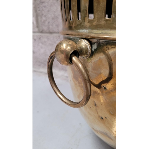 77 - A LATE 19TH / EARLY 20TH CENTURY BRASS COAL / FIRE FUEL BUCKET, with a finial topped lid, pierced de... 