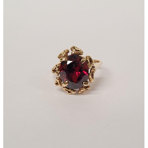 78 - A BEAUTIFUL YELLOW GOLD & GARNET RING, with an open work edge that holds the large oval shaped garne... 