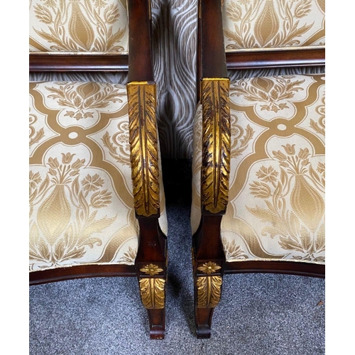88 - A PAIR OF CARVED GILT DECORATED UPHOLSTERED ARMCHAIRS, each with scrolling foliage detail to the cre... 