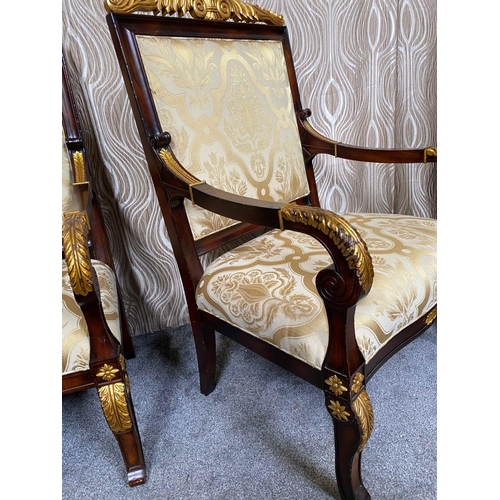 88 - A PAIR OF CARVED GILT DECORATED UPHOLSTERED ARMCHAIRS, each with scrolling foliage detail to the cre... 