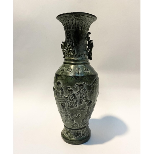 102 - A CHINESE BRONZE URN VASE, with textured fluted design to rim and base, figural design to body in re... 