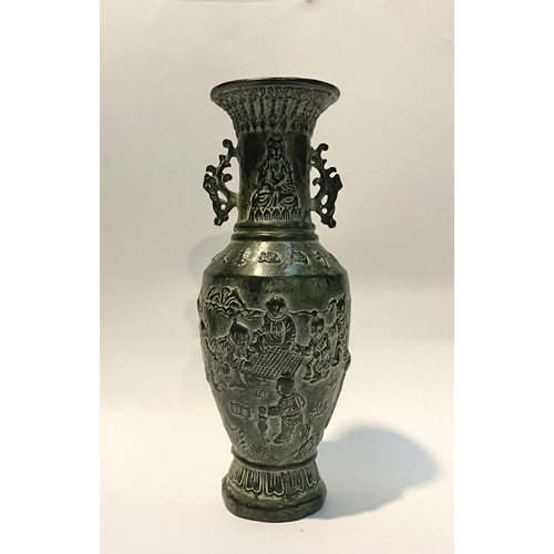 102 - A CHINESE BRONZE URN VASE, with textured fluted design to rim and base, figural design to body in re... 