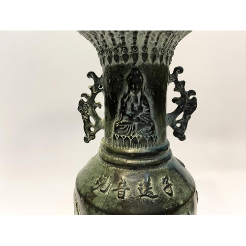 102 - A CHINESE BRONZE URN VASE, with textured fluted design to rim and base, figural design to body in re... 