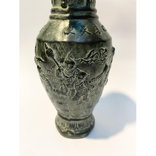 102 - A CHINESE BRONZE URN VASE, with textured fluted design to rim and base, figural design to body in re... 