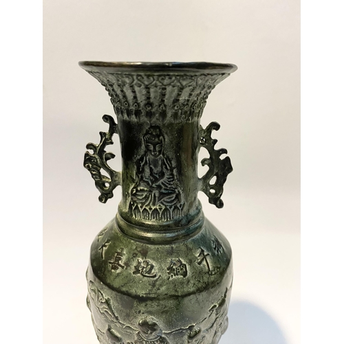 102 - A CHINESE BRONZE URN VASE, with textured fluted design to rim and base, figural design to body in re... 