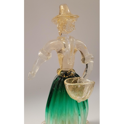 105 - A VINTAGE MURANO STYLE GLASS ORNAMENTAL FIGURINE, depicting a figure holding a basket. The skirt in ... 