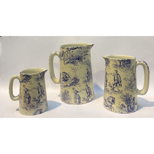 109 - A SET OF THREE BRITISH POTTERY ‘TOILE DE JOUY’ JUGS, in the style of Heron Cross Pottery, each piece... 