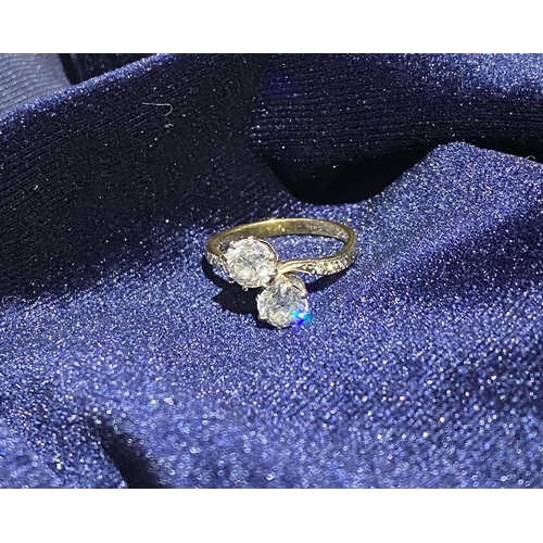 121 - A CLASSIC 18CT YELLOW GOLD TWO STONE DIAMOND TWIST RING, with two round cut diamonds, claw set in be... 