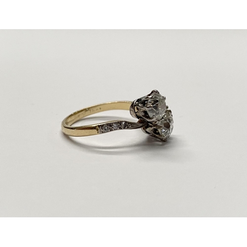 121 - A CLASSIC 18CT YELLOW GOLD TWO STONE DIAMOND TWIST RING, with two round cut diamonds, claw set in be... 