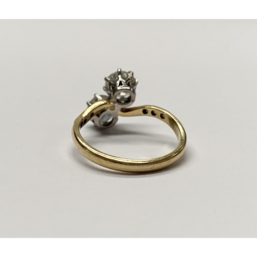 121 - A CLASSIC 18CT YELLOW GOLD TWO STONE DIAMOND TWIST RING, with two round cut diamonds, claw set in be... 