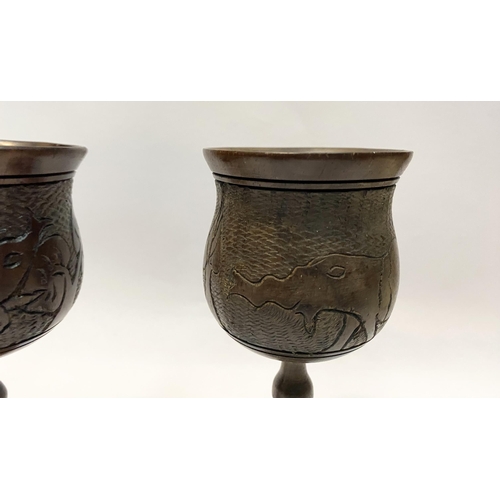 126 - A PAIR OF HARDWOOD CARVED GOBLETS, both with carved scenes to body depicting elephants and with turn... 