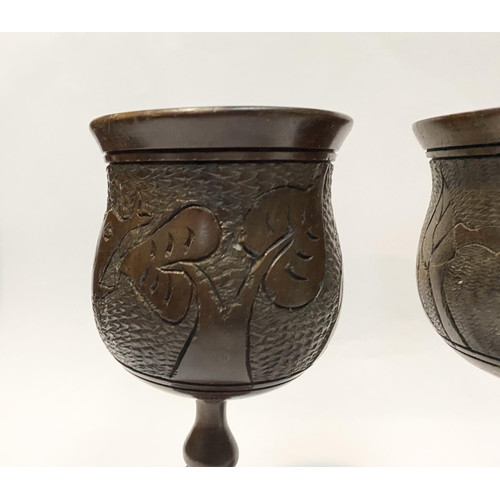 126 - A PAIR OF HARDWOOD CARVED GOBLETS, both with carved scenes to body depicting elephants and with turn... 