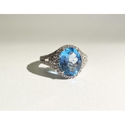 13 - AN EXQUISITE 18CT WHITE GOLD BLUE TOPAZ AND DIAMOND CLUSTER RING, with central large sparkling oval ... 