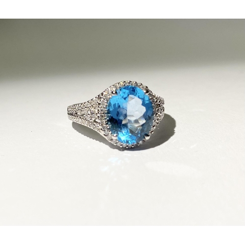 13 - AN EXQUISITE 18CT WHITE GOLD BLUE TOPAZ AND DIAMOND CLUSTER RING, with central large sparkling oval ... 