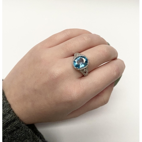 13 - AN EXQUISITE 18CT WHITE GOLD BLUE TOPAZ AND DIAMOND CLUSTER RING, with central large sparkling oval ... 