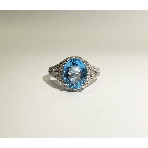 13 - AN EXQUISITE 18CT WHITE GOLD BLUE TOPAZ AND DIAMOND CLUSTER RING, with central large sparkling oval ... 