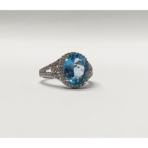 13 - AN EXQUISITE 18CT WHITE GOLD BLUE TOPAZ AND DIAMOND CLUSTER RING, with central large sparkling oval ... 