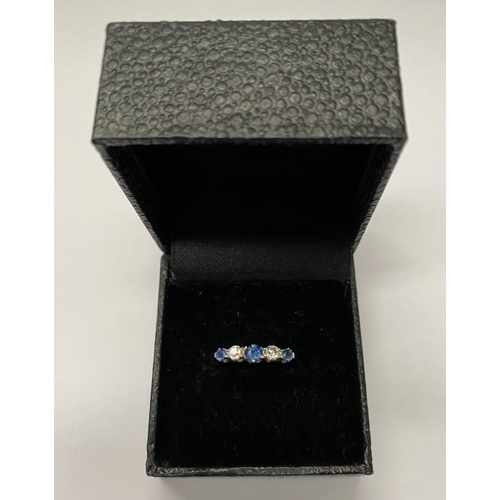 140 - A DAINTY 18CT WHITE GOLD FIVE STONE SAPPHIRE AND DIAMOND RING, with three vibrant round cut sapphire... 