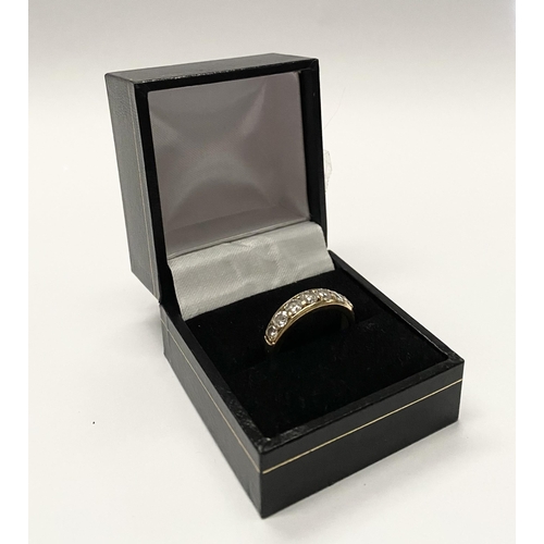 141 - A SPARKLING 18CT YELLOW GOLD SEVEN STONE DIAMOND BAND, with seven round cut diamonds in 18ct yellow ... 