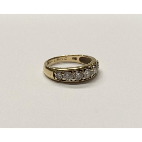 141 - A SPARKLING 18CT YELLOW GOLD SEVEN STONE DIAMOND BAND, with seven round cut diamonds in 18ct yellow ... 