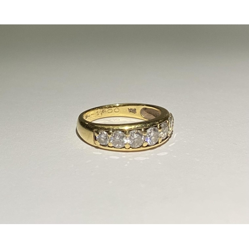 141 - A SPARKLING 18CT YELLOW GOLD SEVEN STONE DIAMOND BAND, with seven round cut diamonds in 18ct yellow ... 