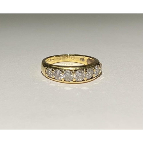 141 - A SPARKLING 18CT YELLOW GOLD SEVEN STONE DIAMOND BAND, with seven round cut diamonds in 18ct yellow ... 