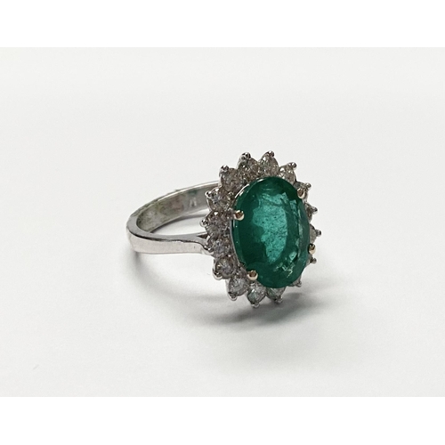 142 - A FANTASTIC 18CT WHITE GOLD EMERALD AND DIAMOND CLUSTER RING, with central vibrant oval cut emerald ... 