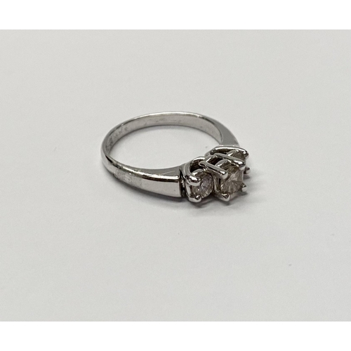 143 - A TRADITIONAL 18CT WHITE GOLD THREE STONE DIAMOND RING, with three round cut diamonds in raised pron... 