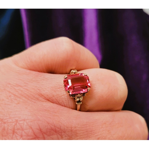 17 - A 10CT YELLOW GOLD BRIGHT PINK TOPAZ RING. The stone is very pretty – with a lovely shade of pink, t... 