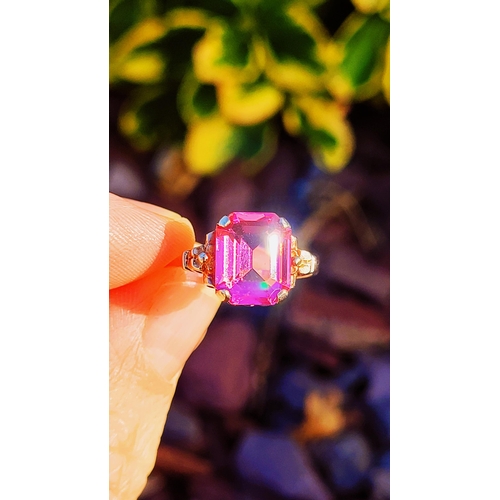 17 - A 10CT YELLOW GOLD BRIGHT PINK TOPAZ RING. The stone is very pretty – with a lovely shade of pink, t... 