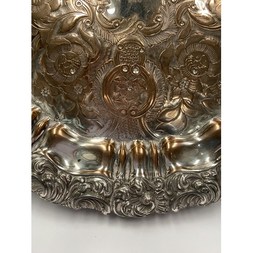 181 - A VERY DECORATIVE SILVER PLATED LARGE SALVER, with engraved cartouche to centre surrounded by engrav... 