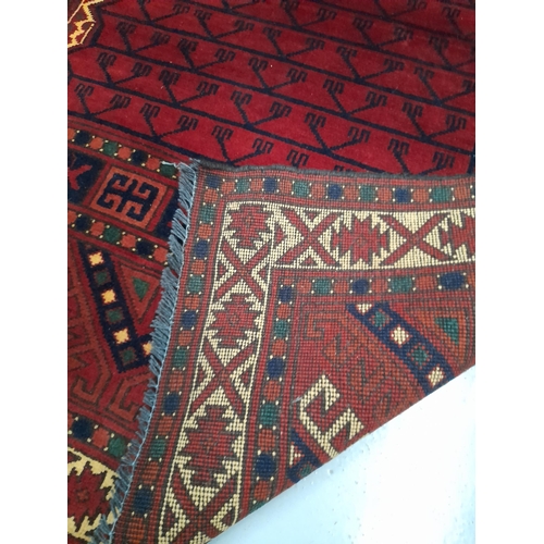 219 - AN EXCELLENT AFGHAN KHARGHAR RUG, hand-woven in the traditional pattern in vibrant red and navy. Dim... 