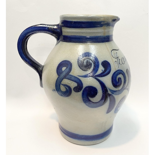 236 - TWO GERMAN SALT GLAZED STONEWARE JUGS, (i) larger pitcher jug with blue painted handle, double band ... 