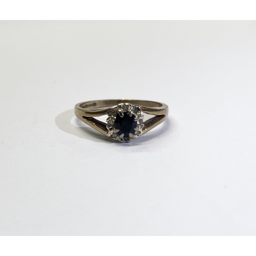 242 - AN ELEGANT 9CT YELLOW GOLD SAPPHIRE CLUSTER RING, with central oval cut sapphire surrounded by eight... 