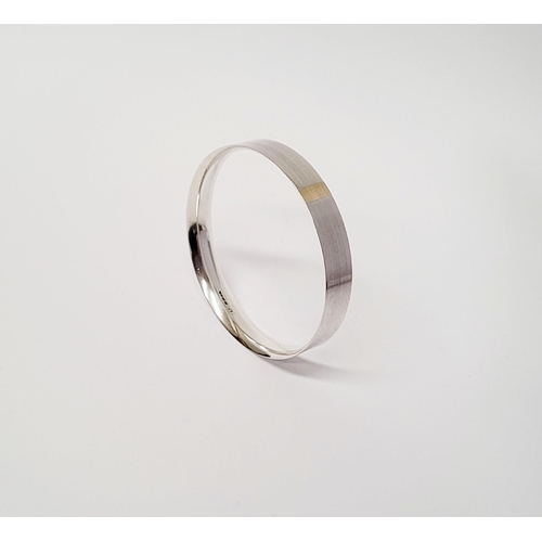 35 - A FINELY CRAFTED COX & POWER STERLING SILVER BANGLE, with brushed finish having a gold coloured stri... 